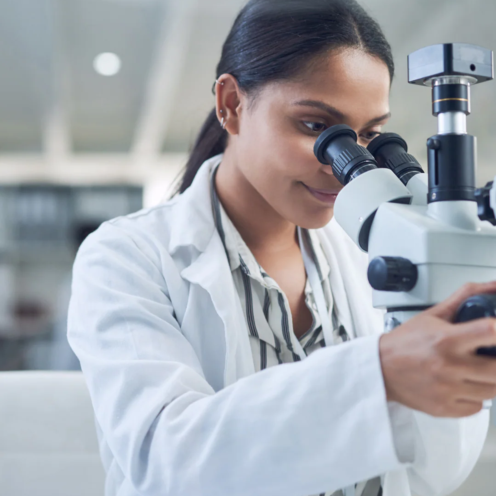 Scientist looking through a microscope in a laboratory setting